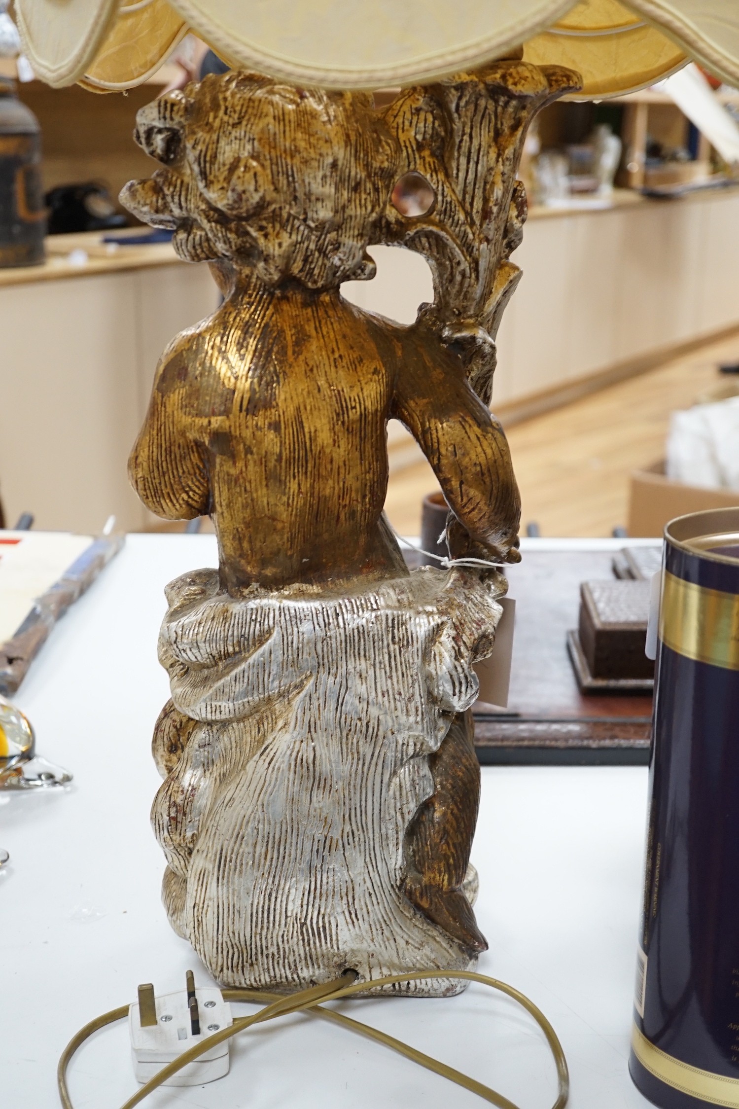A gilt composition putti table lamp. 86cm tall